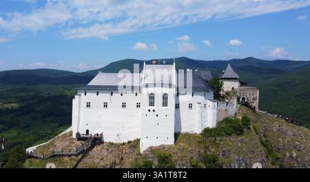 Fortezza medievale ungherese, il castello si erge sulla cima della montagna. Panorama panoramico e vista panoramica. Foresta verde e valle. Luogo ideale per escursioni a piedi. Foto Stock