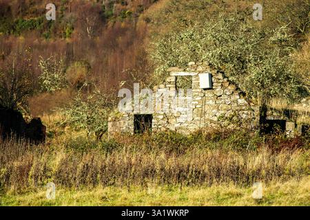 La parete finale di una collina di pietra deserta e decadente si snoda nei Trossachs in Scozia. Foto Stock