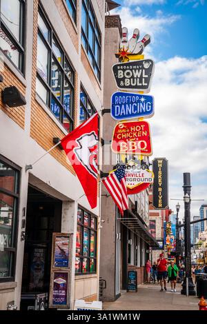 13 ottobre 2023, Nashville, Tennessee: Cartelli per negozi e ristoranti su Broadway Street nel centro di Nashville al semaforo Foto Stock