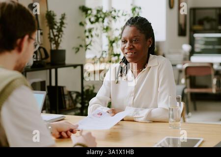 Immagine media di una donna afroamericana fiduciosa che racconta le sue abilità e la sua esperienza lavorativa durante il colloquio di lavoro Foto Stock