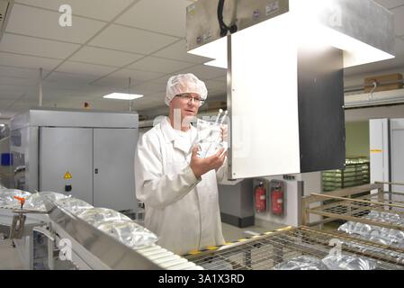 produzione di sacche per infusione per ospedali in una moderna fabbrica medica - controllo di qualità del lavoratore Foto Stock