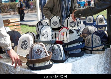 AK-Kalpak, copricapo nazionale maschile del Kirghizistan, materiale tessile in lana feltrata. Mercato all'aperto Foto Stock
