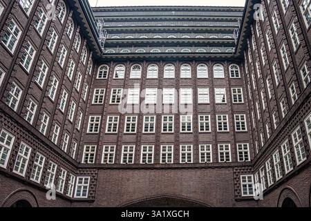 Il cortile interno del Chilehaus, un punto di riferimento ad Amburgo, con la sua caratteristica facciata in mattoni caratterizzata da una geometria di finestre con cornici bianche. Amburgo Foto Stock