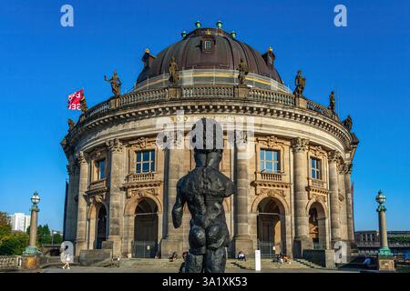 Splendida vista del Bode-Museum, situato sull'Isola dei Musei sulla Sprea con una grande statua nera in primo piano. Berlino, Germania, Europa Foto Stock