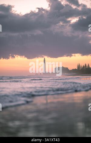 Romantico tramonto sul mare con un faro e nuvole tempestose Foto Stock