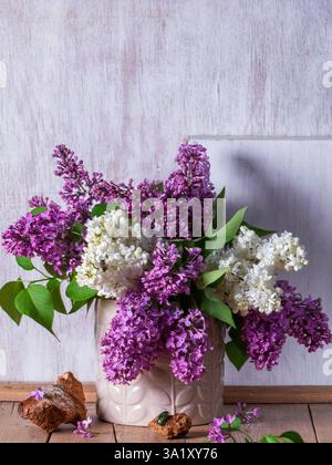 Bouquet di lillate multicolore, trucioli di legno e insetti su sfondo chiaro. Foto Stock