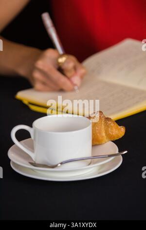 Persona che firma un libro degli ospiti in un bar Foto Stock