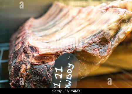 L'invecchiamento a secco di manzo marmorizzato si trova nel frigorifero di un ristorante. Carne di manzo invecchiata a secco, impiccata in frigorifero per mesi. Foto Stock