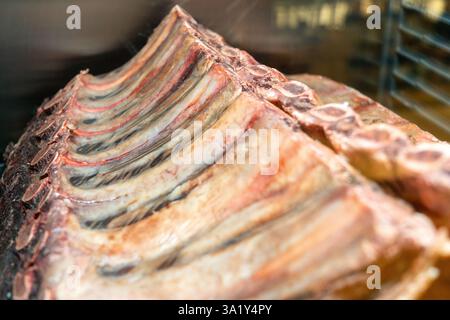 L'invecchiamento a secco di manzo marmorizzato si trova nel frigorifero di un ristorante. Carne di manzo invecchiata a secco, impiccata in frigorifero per mesi. Foto Stock