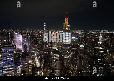 Panorama dello skyline di New York con le luci luminose dei grattacieli di Manhattan che illuminano il cielo notturno; vista aerea sul centro di New York Foto Stock