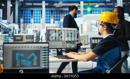 Esperto di impianti per pannelli solari che istruisce il tecnico su come sfruttare al meglio l'energia solare. Un ricercatore afroamericano della fabbrica fotovoltaica mostra ai lavoratori come migliorare l'efficienza, macchina fotografica A. Foto Stock