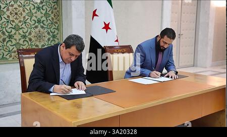 il presidente ad interim della Siria Ahmed al-Sharaa (R) e il comandante in capo delle forze democratiche siriane (SDF) Mazloum Abdi firmano un accordo per integrare le istituzioni dell'amministrazione curda semi-autonoma nel nord-est nel governo nazionale, nella capitale siriana Damasco il 10 marzo 2025. Foto della Syrian Arab News Agency (sana)/UPI Credit: UPI/Alamy Live News Foto Stock
