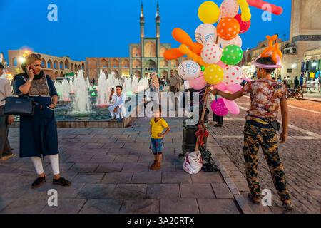 Venditore di mongolfiere per bambini al tramonto in piazza Amir Chakhmag nella città di Yazd in Iran. Complesso Amir Chakhmaq, romanizzato: Majmūʿa Meydân Amir Foto Stock