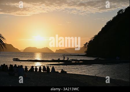Persone che ammirano lo splendido tramonto sulla spiaggia di Vanilla nelle Filippine. Foto Stock