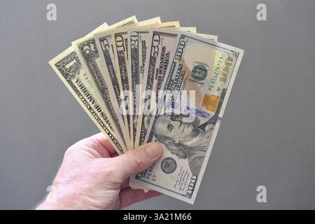 Banconote in dollari correnti 1, 2, 5, 10, 20, 50, 100 dollari come fan in mano Foto Stock