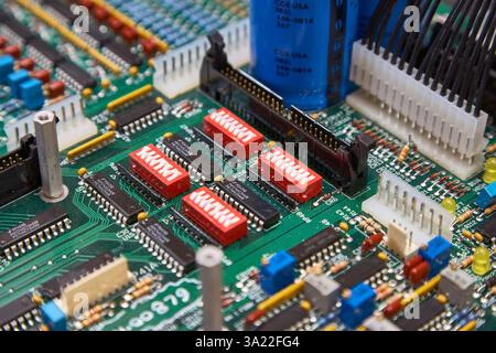 Primo piano dei componenti della scheda a circuito stampato e degli interruttori su un circuito stampato verde Foto Stock
