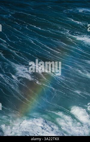 Arcobaleno visto durante il surf sulle grandi onde a Praia do Norte (North Beach), elencato nel Guinness World Records per le più grandi onde mai surfate, si è formato Foto Stock