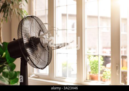 Ventola di raffreddamento elettrica con nastri soffianti davanti al finestrino nelle calde giornate estive Foto Stock