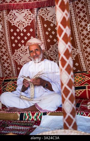 Khalifa, creatore di cesti, che fa una dimostrazione del suo mestiere nel recinto del forte di Nizwa, regione ad Dakhiliyah, Sultanato dell'Oman, penna araba Foto Stock