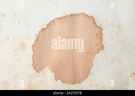 macchie di caffè o tè di colore marrone su un pezzo di vecchia superficie di carta, vista ravvicinata presa direttamente dall'alto con spazio di copia Foto Stock