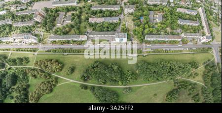parco cittadino pubblico vicino al quartiere residenziale. alberi verdi e prati con sentieri. ora legale. vista aerea panoramica. Foto Stock