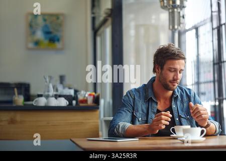 Uomo, felice e rilassati nel bar con una tazza di caffè espresso, pausa e soddisfazione del cliente. Servizio di ospitalità, ristorante e relax con moka Foto Stock