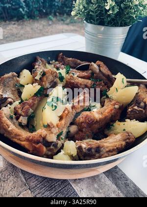 Braciole di maiale arrosto e patate fritte cucinate all'aperto in campeggio. Direttamente sopra. Foto Stock