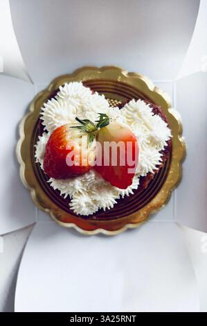 Torta a forma di cuore di San Valentino con panna e fragole. Direttamente sopra. Foto Stock