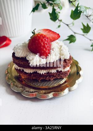 Torta a forma di cuore di San Valentino con panna e fragole. Direttamente sopra. Foto Stock