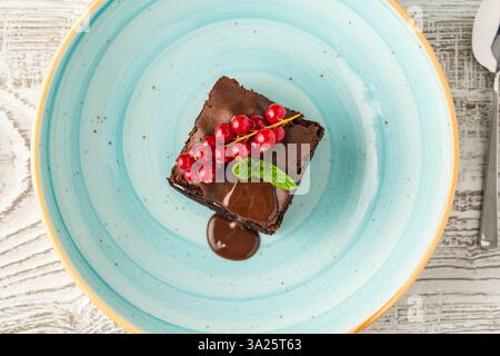 Brownie alla menta al cioccolato con ripieno di panna, salsa al cioccolato e frutti di bosco Foto Stock