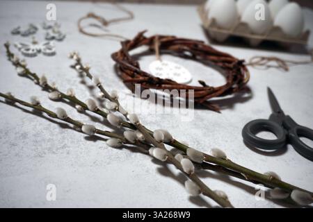 corona pasquale di rami di viti con filetto su sfondo grigio con copyspace. decorazione con uova Foto Stock