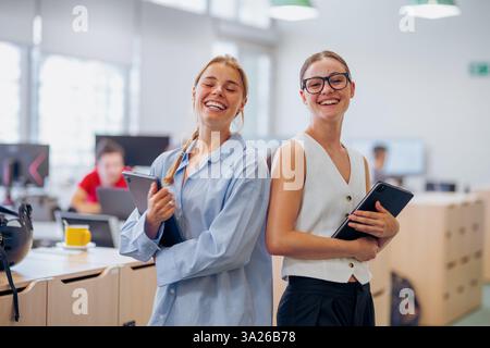 Gruppo di giovani professionisti che sorridono e collaborano in un moderno spazio Office Environment Foto Stock