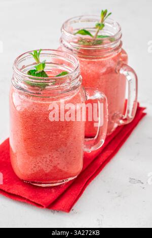 Frullato tropicale cremoso con ciliegia, banana e ananas nei vasetti mason Foto Stock
