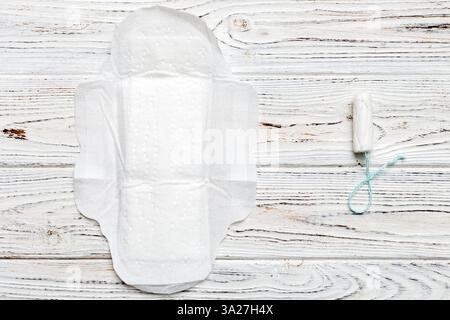 tamponi e tampone donna - tamponi sanitari si trovano accanto a un tampone su uno sfondo isolato su sfondo rosa e viola. Igiene femminile e mestruale p Foto Stock
