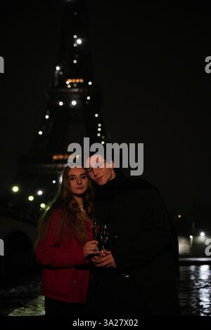 Un momento bello e romantico è stato catturato con una coppia, immersi nel caldo bagliore della Torre Eiffel a Parigi Foto Stock