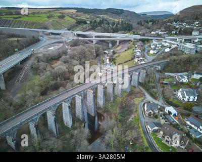 Viadotto ferroviario in disuso sul fiume Taf in Galles, con la strada Heads of the Valleys sullo sfondo Foto Stock