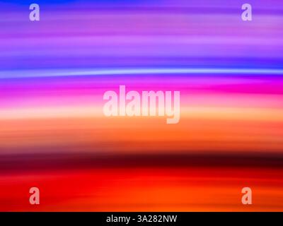 Strati di tonalità vivaci si estendono attraverso il cielo e si fondono perfettamente al tramonto. Questa incantevole esposizione di colori crea un'atmosfera rilassante Foto Stock