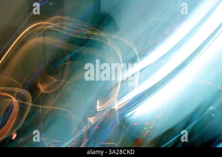Un'immagine astratta caratterizzata da percorsi luminosi dinamici e movimento sfocato, che crea un senso di energia e movimento. I colori sono prevalentemente blu con h Foto Stock