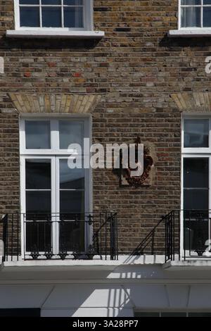 Cappotto d'arme con ferro di cavallo capovolto e trifoglio sull'edificio di Chelsea Londra Inghilterra (Heraldry) Foto Stock
