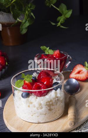 Delizioso budino di riso con vari frutti di bosco e frutti rossi Foto Stock
