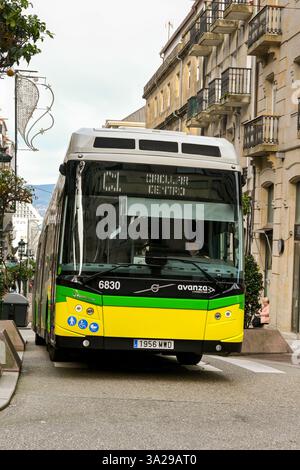 Vigo, Spagna - 14 gennaio 2025: Autobus di servizio pubblico che attraversa una delle stradine della città di Vigo Foto Stock