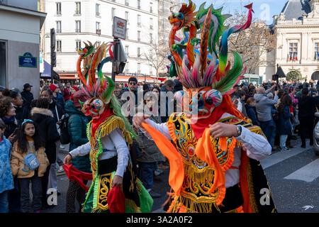 Vivaci ballerini in maschera riempiono le strade durante le colorate celebrazioni del Carnevale di Parigi 2025 Foto Stock