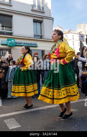 Ballerini vivaci mettono in mostra abiti tradizionali durante le celebrazioni del Carnevale di Parigi 2025 nel cuore della città Foto Stock