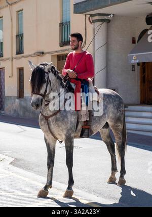 Giovane spagnolo a cavallo di un cavallo grigio nella città di Salar, Andalusia, Spagna Foto Stock
