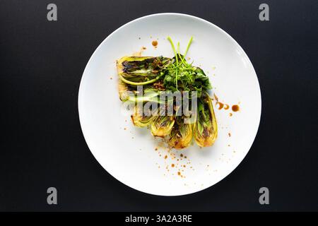 Il bok choy fresco con erbe aromatiche su un elegante sfondo mostra l'eleganza culinaria asiatica. Foto Stock