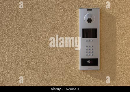 Moderno sistema interfono con telecamera, tastiera e accesso RFID su pareti ruvide alla luce del sole. Tecnologia di sicurezza per edifici residenziali e commerciali Foto Stock