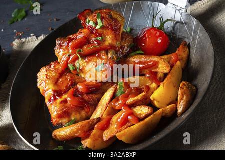 Ali di pollo rustiche in miele con zeppe di patate Foto Stock