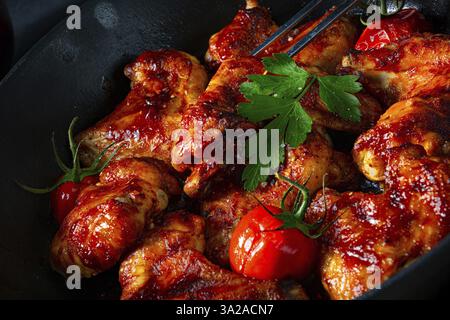 Ali di pollo saporite nel miele con spicchi di patate Foto Stock