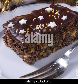 Torta natalizia con semi di papavero con cioccolato, noci e uva sultanina Foto Stock