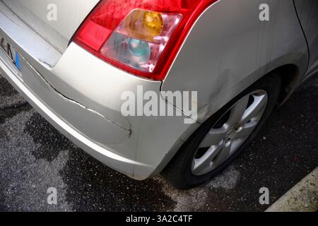Lombardia, Italia 1 marzo 2025 paraurti posteriore Silver Suzuki Swift che mostra ruggine, incrinature e deterioramento della vernice che segnalano l'automotiv immediato Foto Stock
